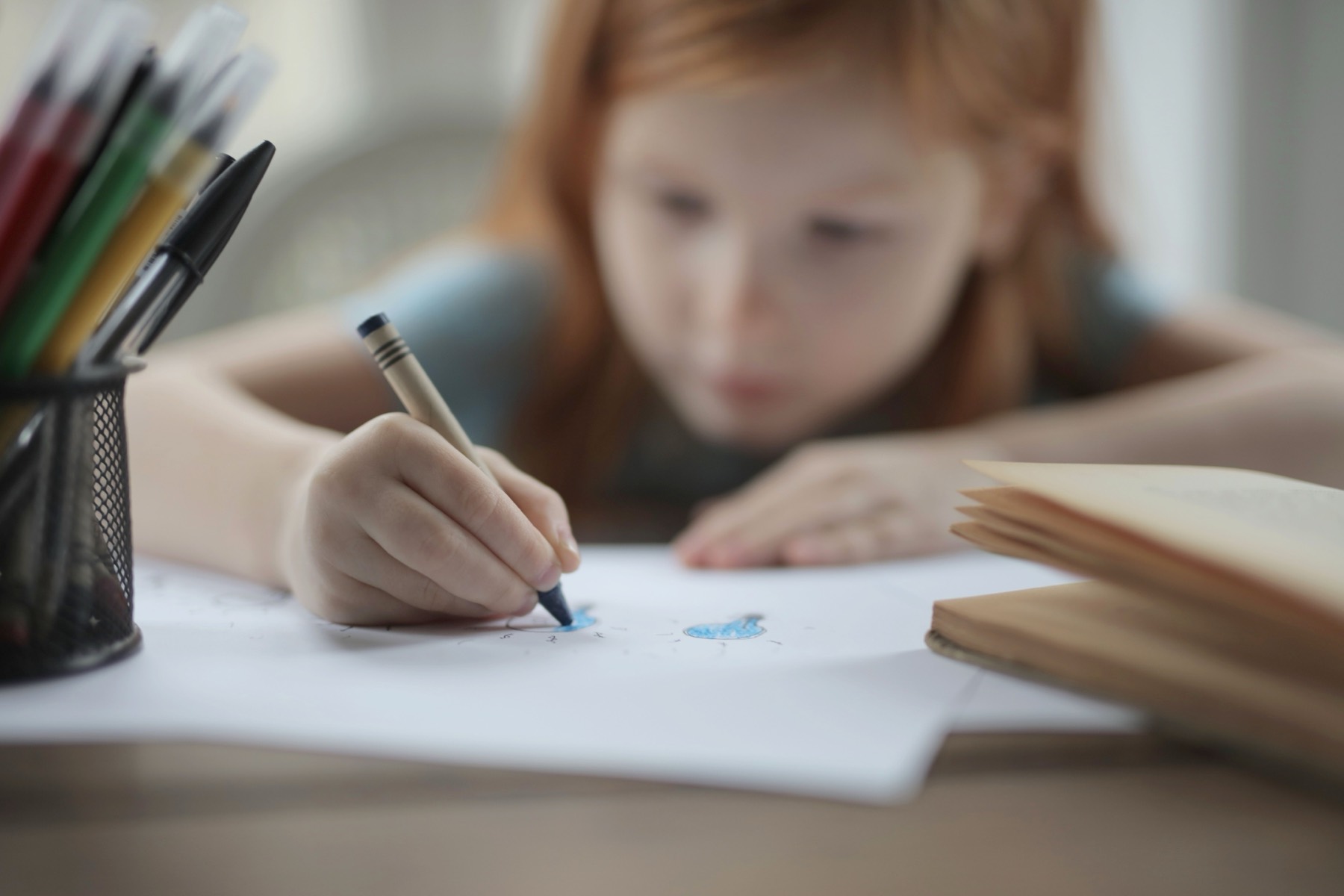 A younger student drawing at a desk