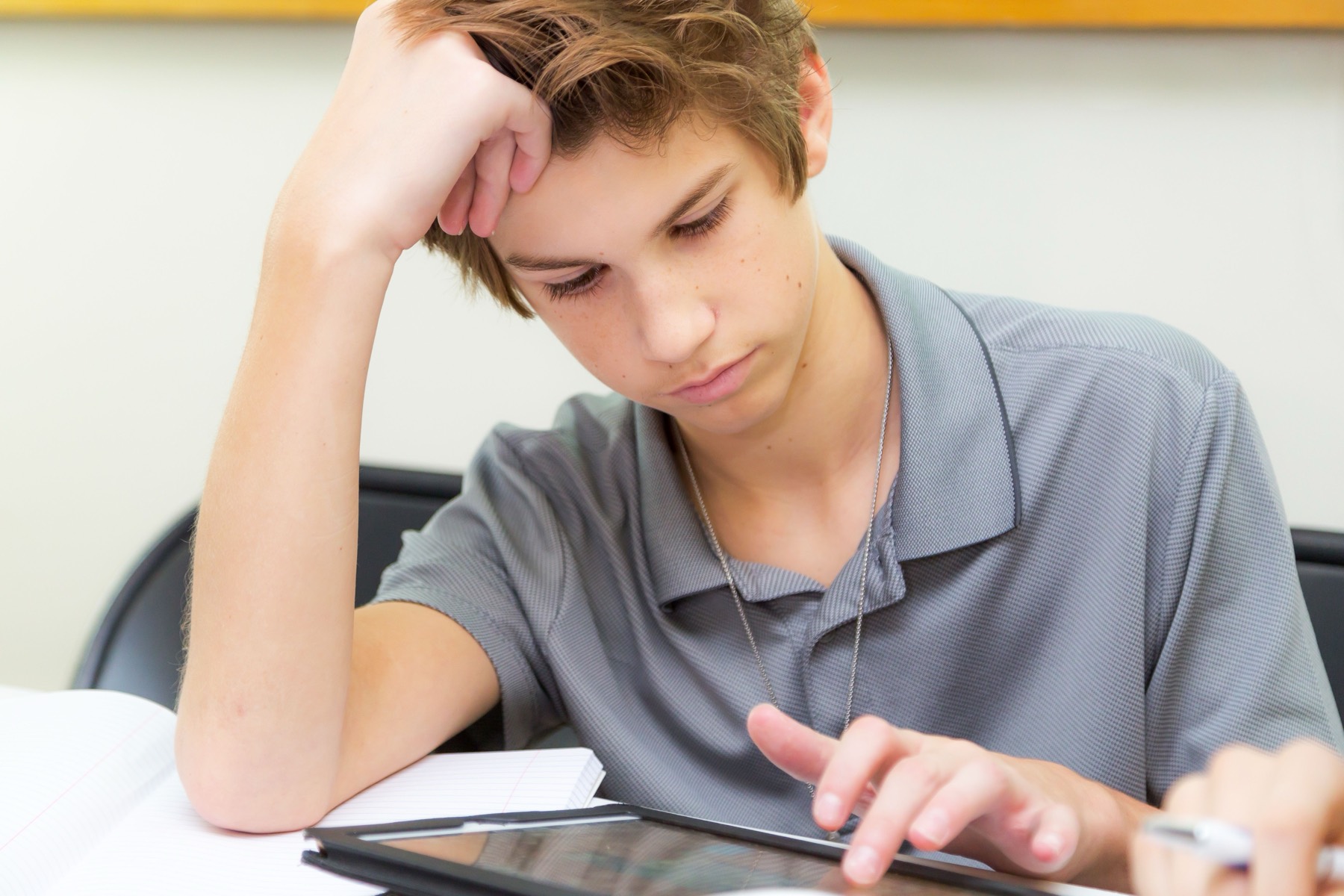 A high school student working on a tablet